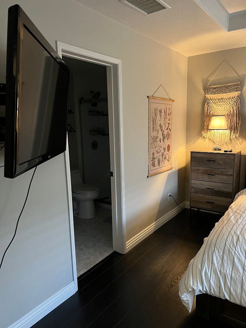 Mounted TV in the corner of the primary bedroom