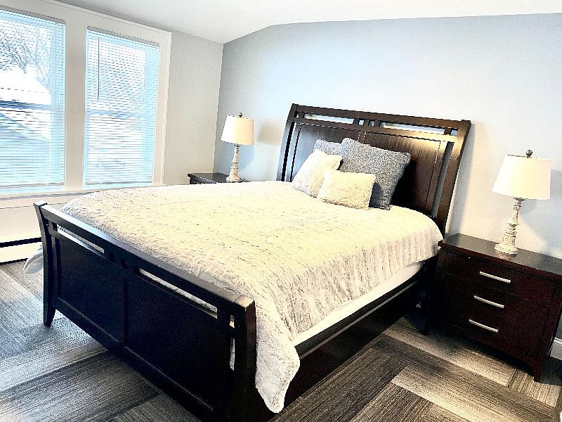 Bright, inviting bedroom with a soft & comfortable bed and nightstands w/lights