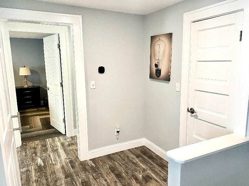 Spacious hallway leading to a cozy bedroom, with modern decor & storage closet