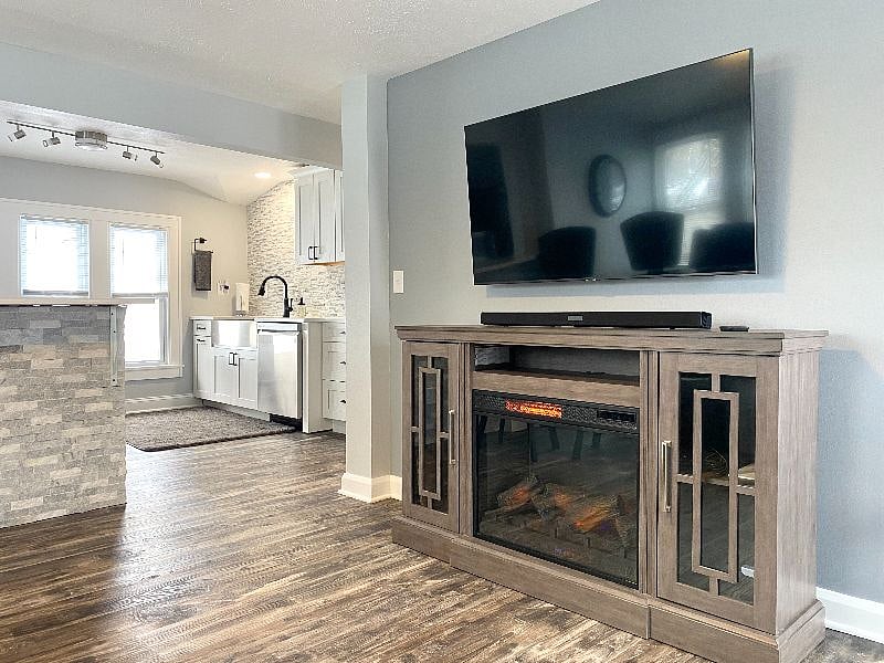 Modern living space with a cozy fireplace, smart TV & stylish open space kitchen