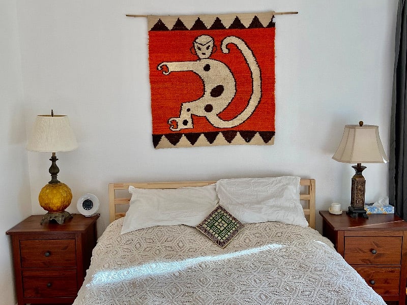 Queen size mattress with vintage lamps and wall hanging