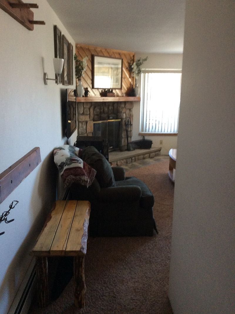 Entryway with coat rack and spot to remove and store shoes.