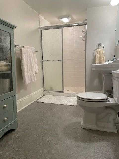 Spacious bathroom with tiled walk-in shower and storage