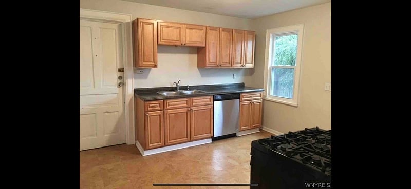 Large kitchen with full sized fridge, gas stove and basic cooking supplies.