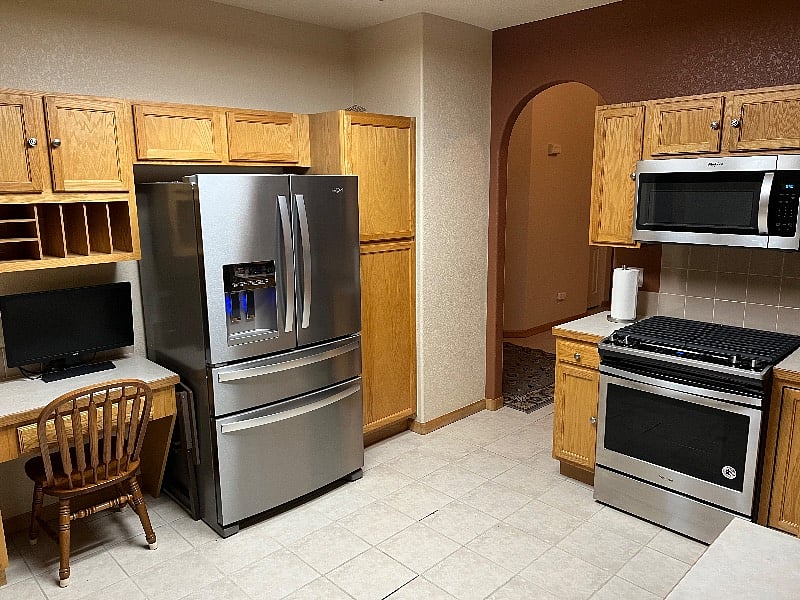 Fridge and Stove new in 2022. Desk with computer monitor.