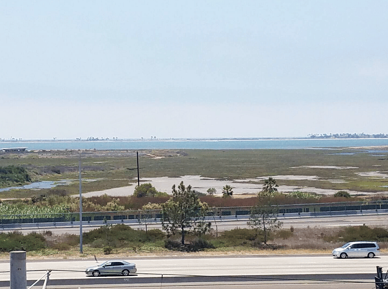 Daytime View of San Diego Bay looking over Sweetwater Marsh in the San Diego National Wildlife Refuge, Silver Strand State Beach, Coronado Island, and the Pacific Ocean in the Distance, beyond Interstate 5 (I-5) freeway