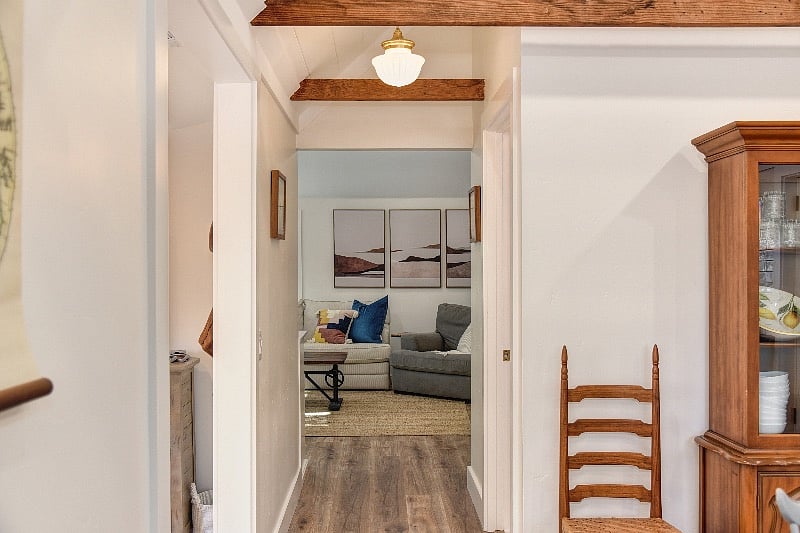 Walk way from kitchen into 1st bathroom on right side, living room ahead, and game-room on left side.