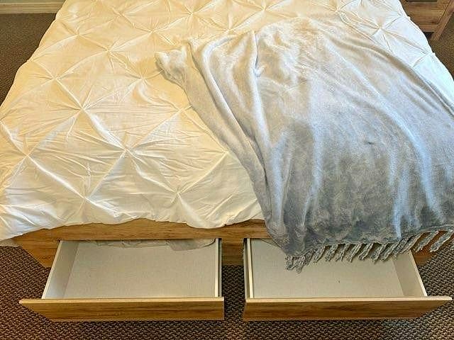 Queen bed equipped with large underbed drawers for additional storage.