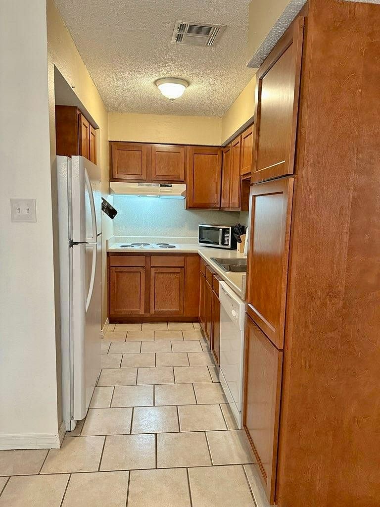 Fully equipped kitchen includes refrigerator/freezer, dishwasher, microwave, and coffee maker for K-cups.