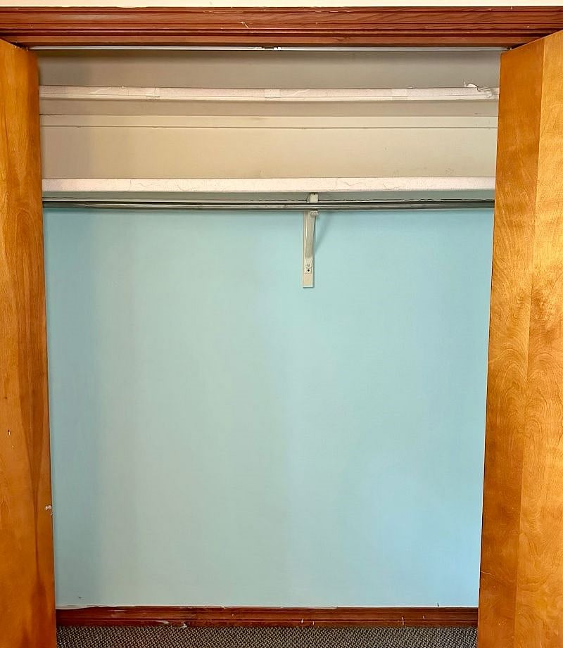 Spacious bedroom closet and storage shelf.