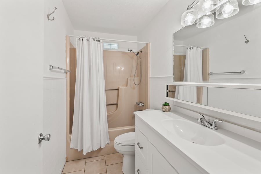 Bright, clean bathroom with classic white finishes. Enjoy a full-length countertop, large vanity cabinet with ample storage, and a wide mirror that makes getting ready a breeze. The full-sized tub is perfect for a relaxing soak, and the spacious linen closet keeps essentials neatly tucked away.