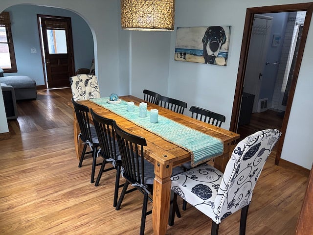 Rustic dining room table with new side and uphostered chairs. Fun coastal art throughout cottage. 
