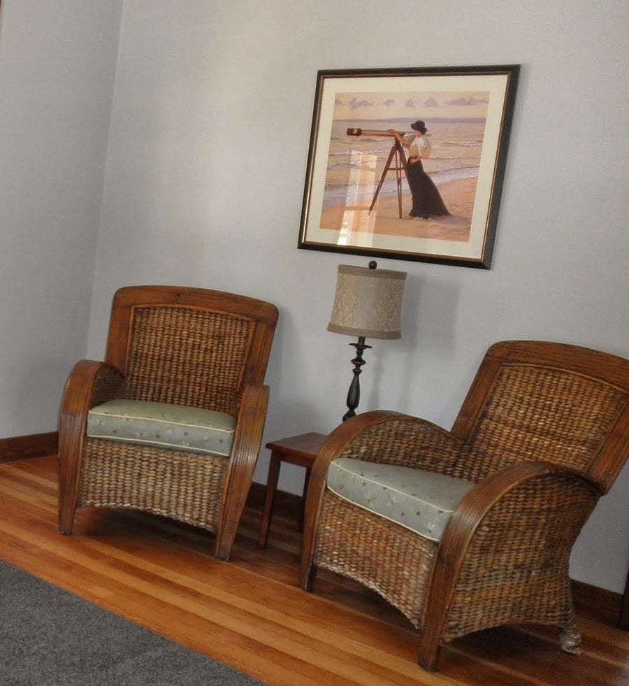Chairs across from the sofa. High quality smart TV mounted on the wall above them. 