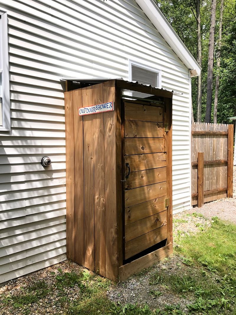 Outdoor shower in fenced in backyard