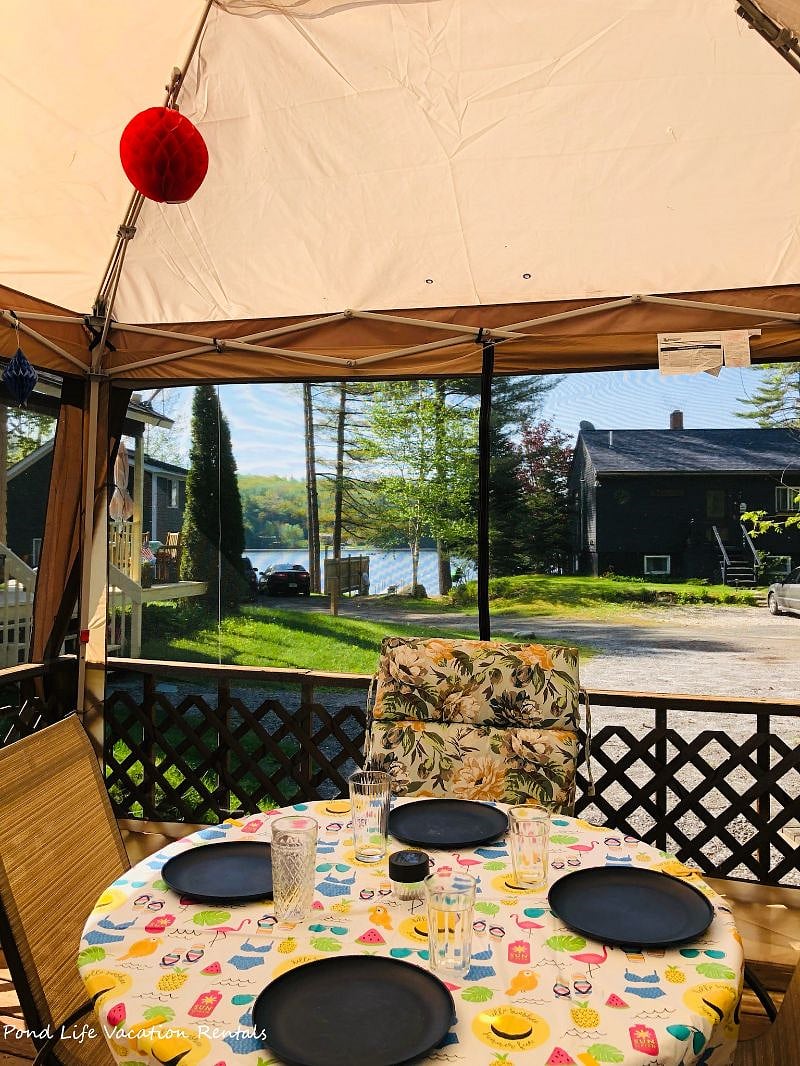 Outdoor sitting area under screened canopy with water views