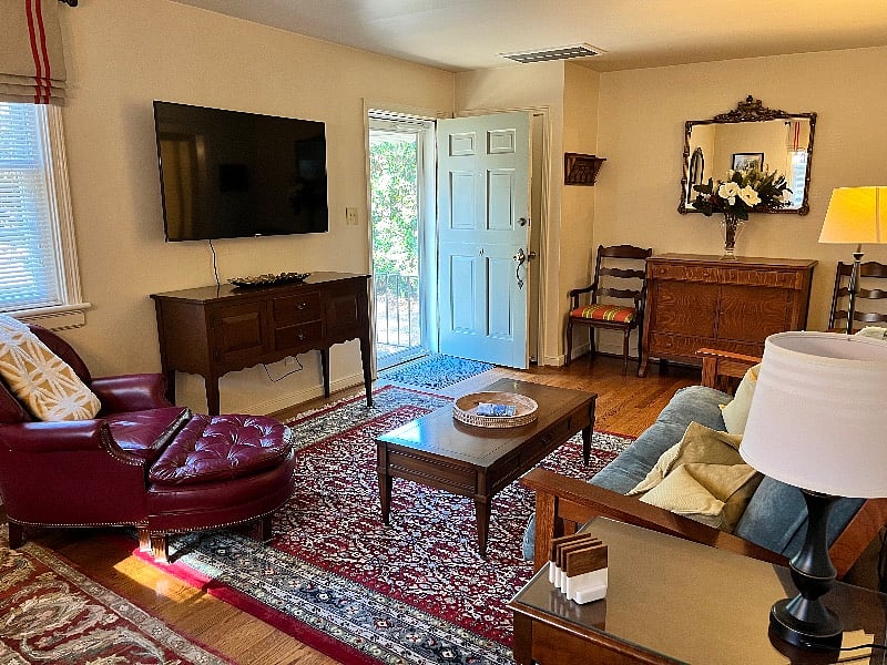 Large, open living room with plenty of natural light and comfortable furniture to sit back, relax and watch your favorite program on the Phillips 55 inch 4k Roku Smart LED TV.