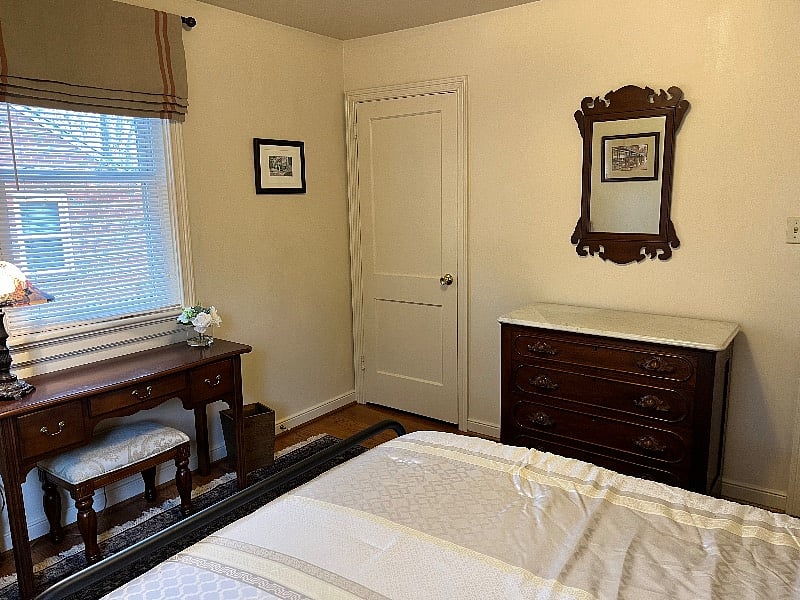Bedroom 2 has a queen size bed, an antique mahogany dresser, a mahogany desk, chair and closet with hangers.  The bedroom has been appointed with elegant custom window treatments and a beautiful oriental rug.