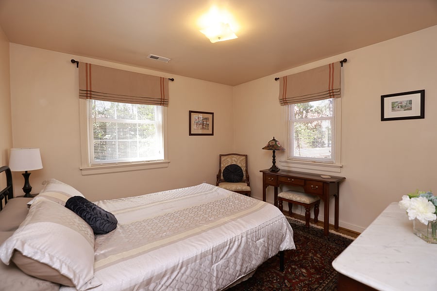 Bedroom 2 has a queen size bed, an antique mahogany dresser, a mahogany desk, chair and closet with hangers.  The bedroom has been appointed with elegant custom window treatments and a beautiful oriental rug.
