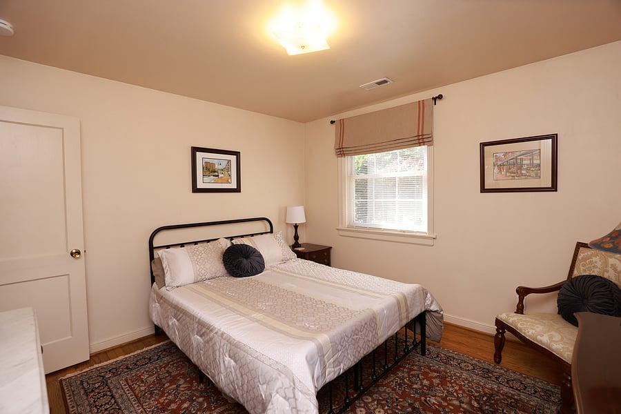 Bedroom 2 has a queen size bed, an antique mahogany dresser, a mahogany dresk, chair and closet with hangers.  The bedroom has been appointed with elegant custom window treatments and a beautiful oriental rug.