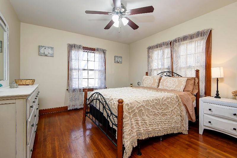 Bright and sunny, bedroom 1 has a full-size bed, dresser, and nightstand.