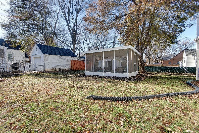 Fenced backyard with shed and outdoor screened-in entertainment room.