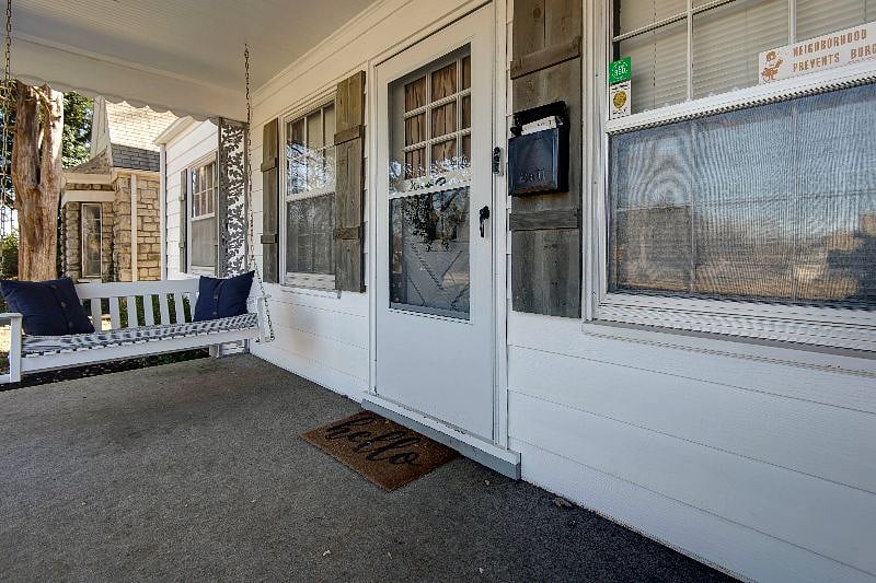 Breezy front porch with ring doorbell, security screen door, and porch swing.