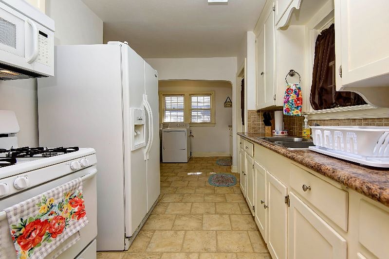 Galley kitchen with gas stove and side-by-side refrigerator