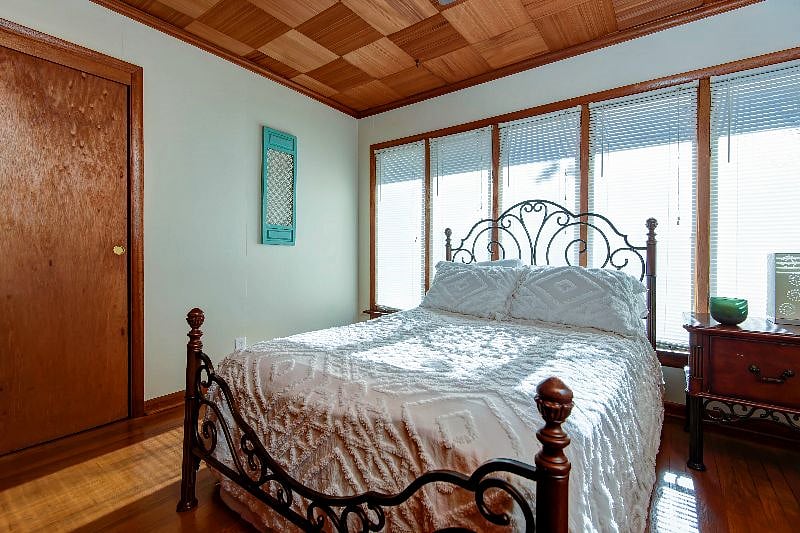 Bedroom 2 has a full size bed and a row of windows.