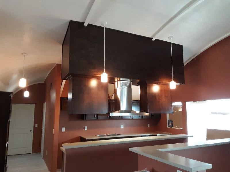 Family kitchen on entry level.  Note the high arched ceiling for an open, airy design.  Includes a black cook top and over sized exhaust system.  Plenty of lighting here and we can share this space.