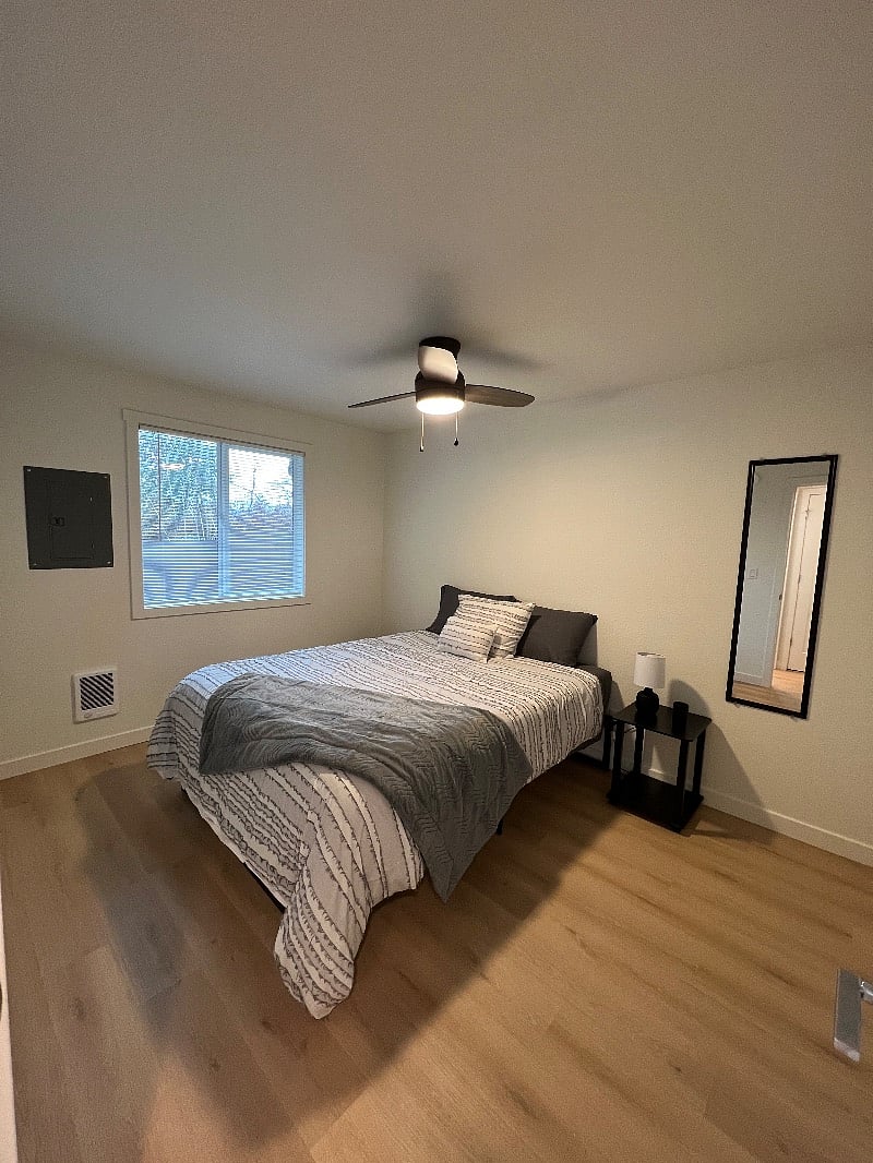 Bedroom 2 features a queen size bed, a large closet with ample storage space (behind the photographer), ceiling fan/light