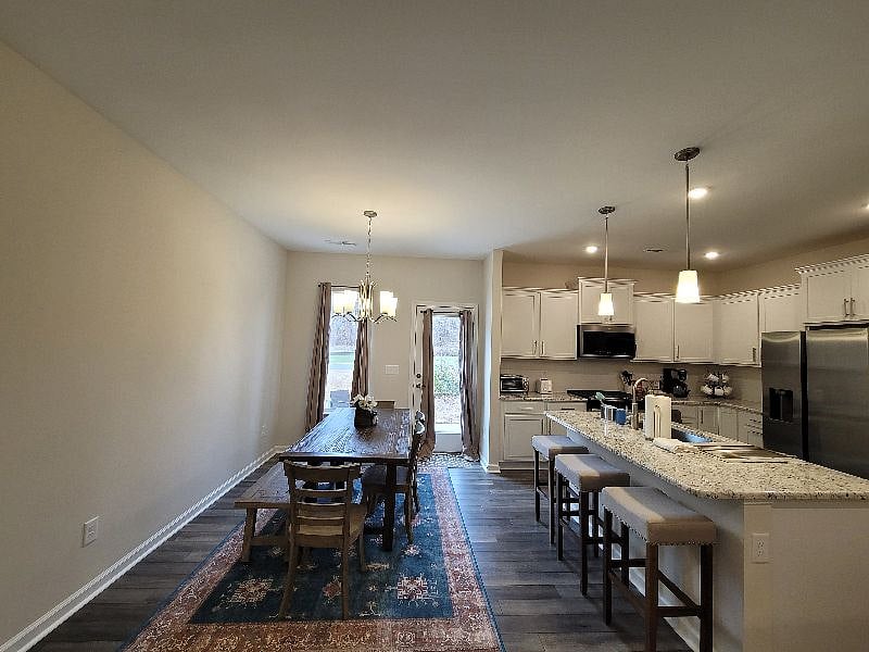 Comfy and open living space with sofa bed, eat-in kitchen, and kitchen with all essentials and a 75 inch large screen TV.