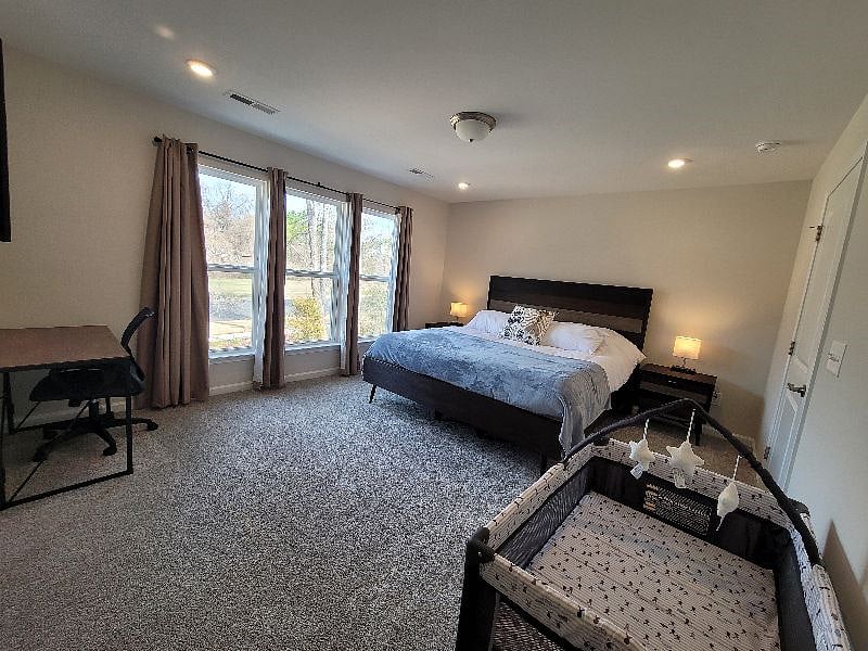 Master Bedroom with Crib as needed, work space, personal smart TV, with en suite deluxe bathroom with all essentials, and walk-in closet.