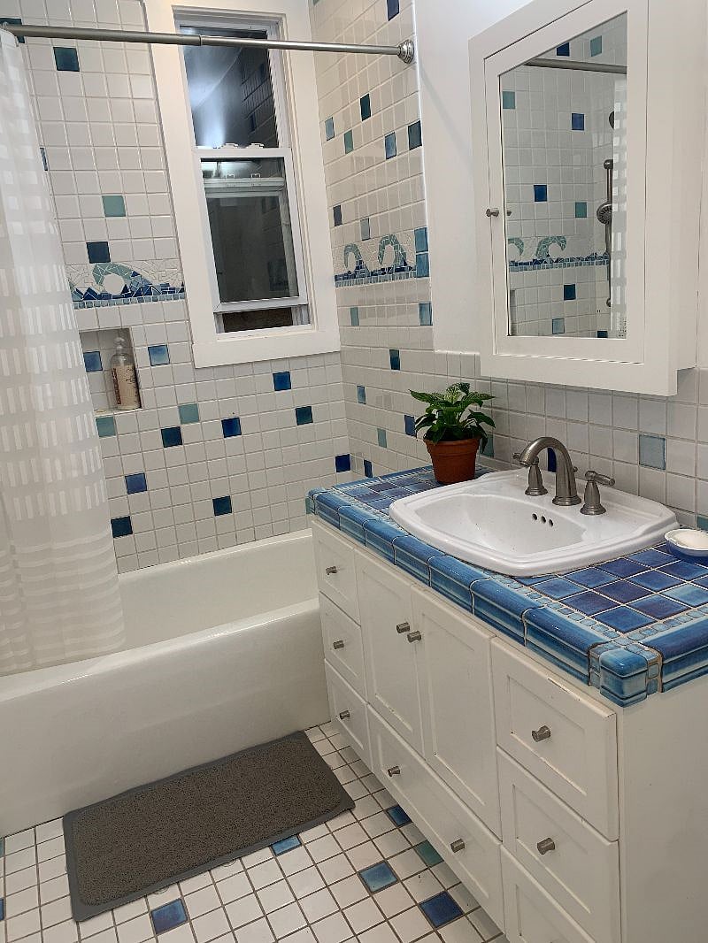 Downstairs shared full bathroom with shower-tub.  Featured tile design.  