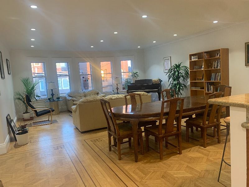 Living and dining rooms with kitchen counter visible. 