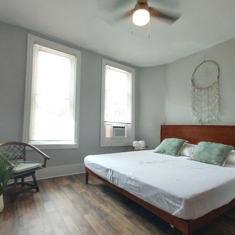 BEDROOM 1 - Super spacious King bedroom with chest of drawers and bamboo chair. Large bright windows that soak the room with warmth.