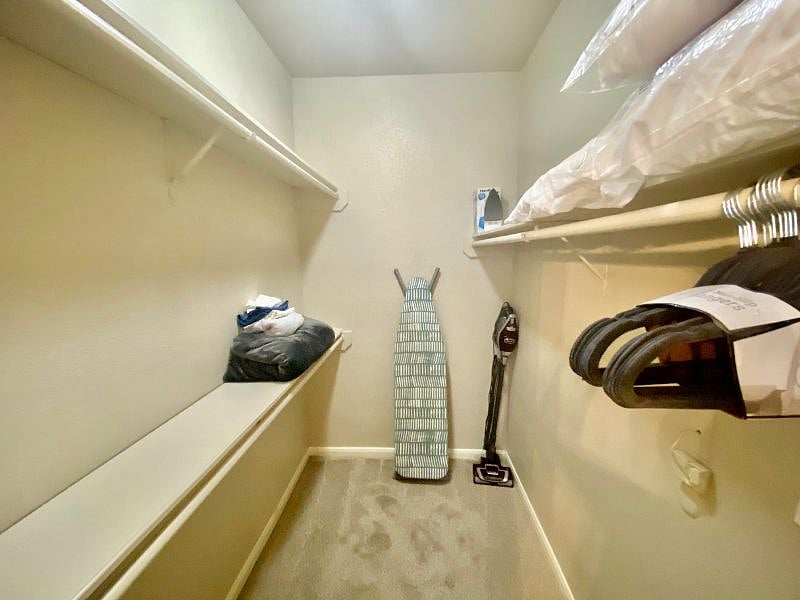 Huge walkin closet with ironing board, iron, clothes steamer, extra blankets, sheets and pillows.