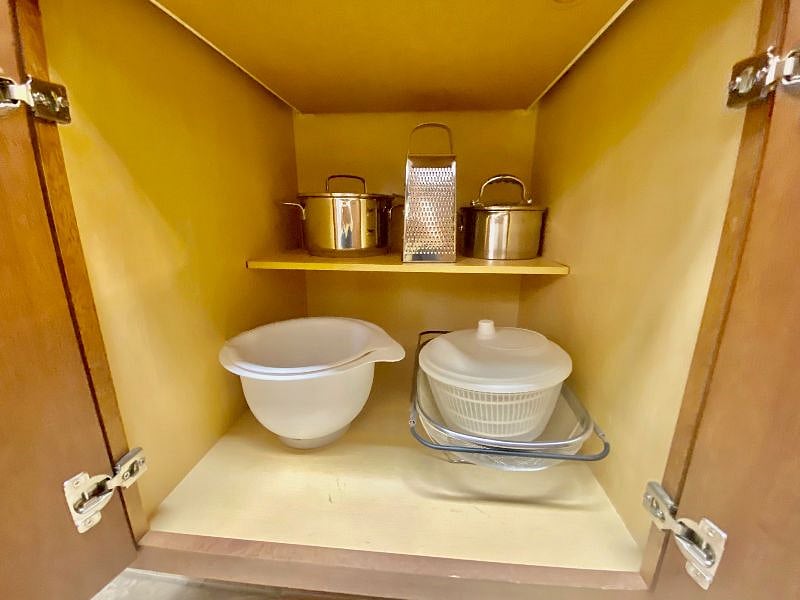 Mixing bowls, pots, cheese grater, collander and salad spinner.