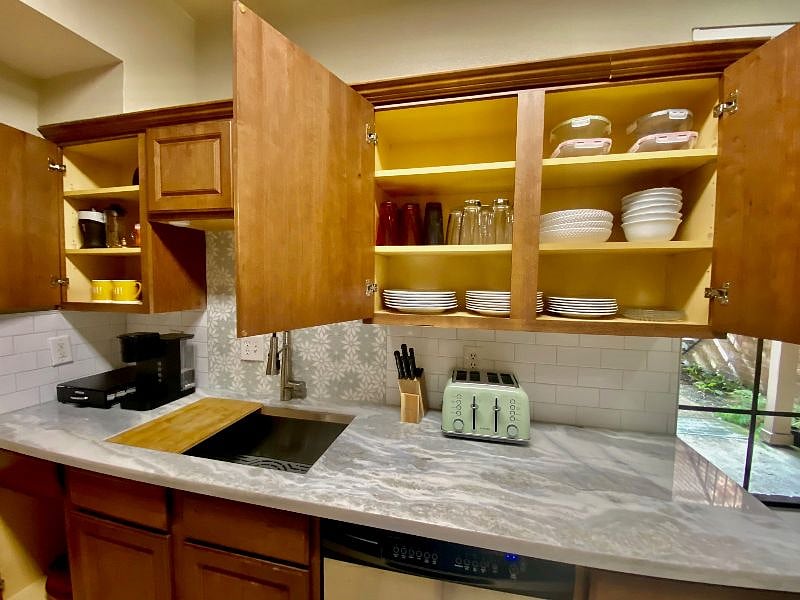 Cabinets are stocked with lots of beautiful dishes so you're not running the dishwasher every time you eat. There's also glass storage containers for leftovers.