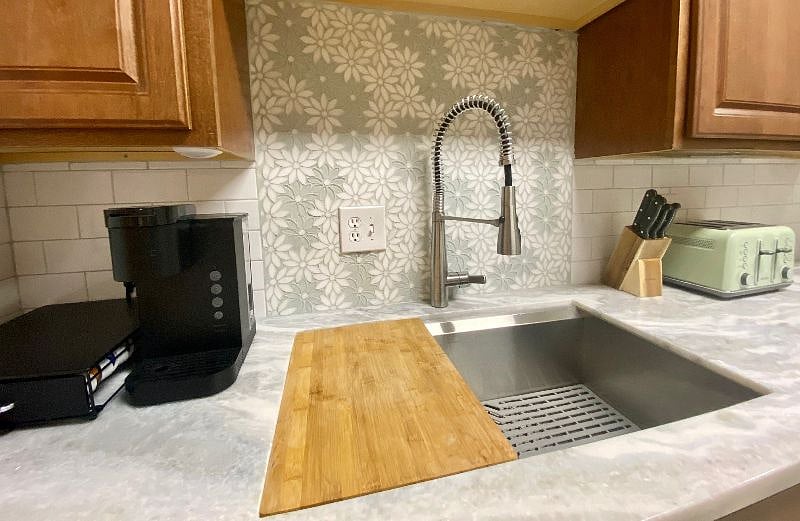 Over sized sink and new kohler faucet with spray nozzle. Cutting board fits directly onto sink. Keurig coffee station, chef knives block and Buydeem 4 slot toaster.