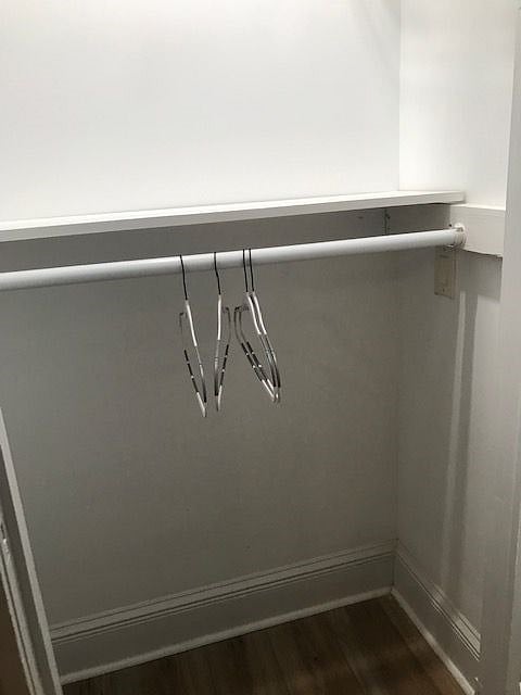 a large closet with double hung racks and shelves on top of the hanging racks offer plenty of space for your clothes and shoes.
