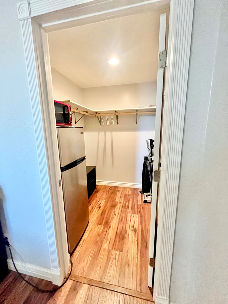 Walk-in closet with refrigerator/freezer and microwave.
