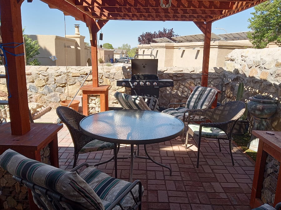 Newly renovated backyard BBQ area with outdoor seating and misting system and lotus flower outdoor fountain.