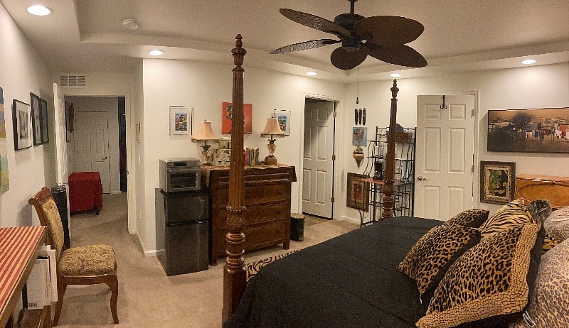 Bedroom looking toward bathroom and including kitchenette. Walk-in closet on right of bakers rack. Kitchette includes a coffee maker, toaster, versitile air fryer/oven, crockpot, kitchen tools, towels, etc.  and small frig. Access to full kitchen below as desired. Also access to freezer space in garage and kitchen.