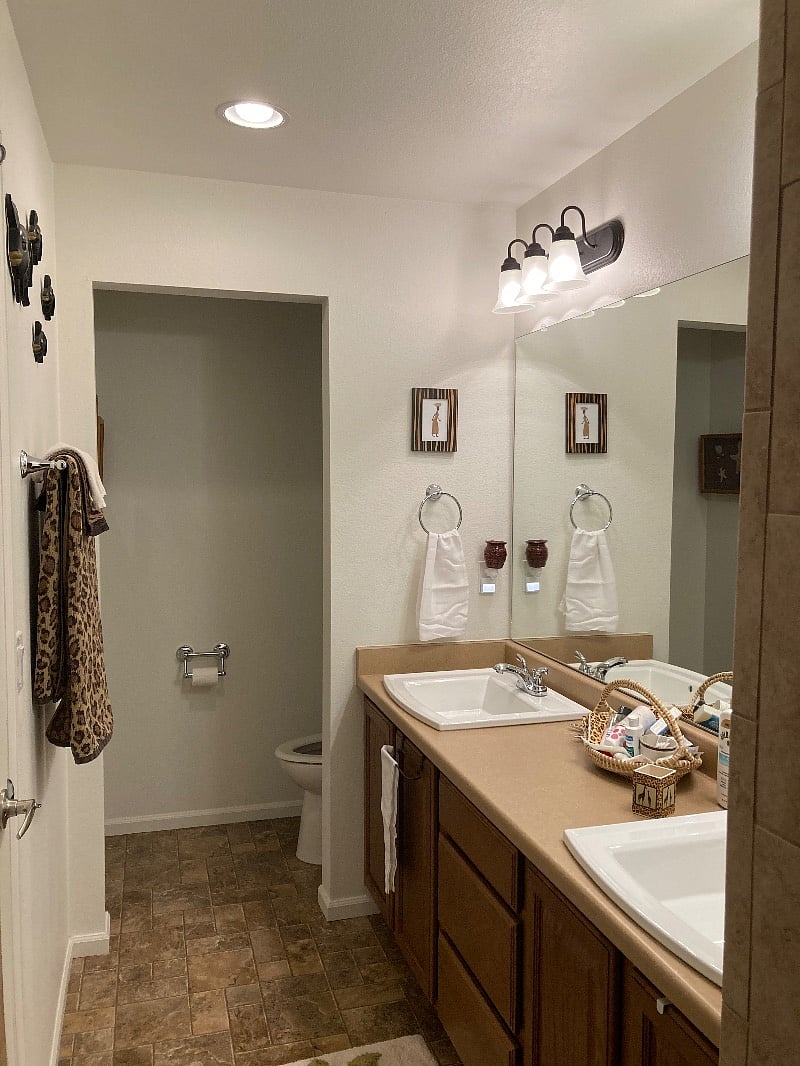 Bathroom looking from inside the walk-in shower towards the toilet area. Includes the first sink. 