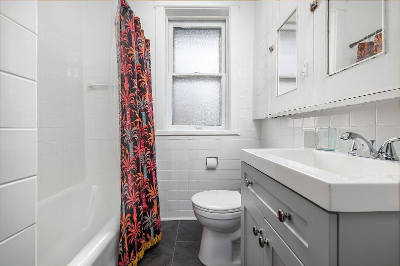 Bathroom features full sized tub/shower, vanity, and built ins with plenty of storage.