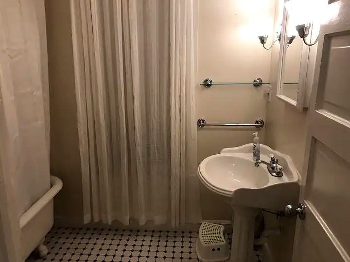 The bathroom is on the first floor and has a sink, toilet and classic clawfoot tub.