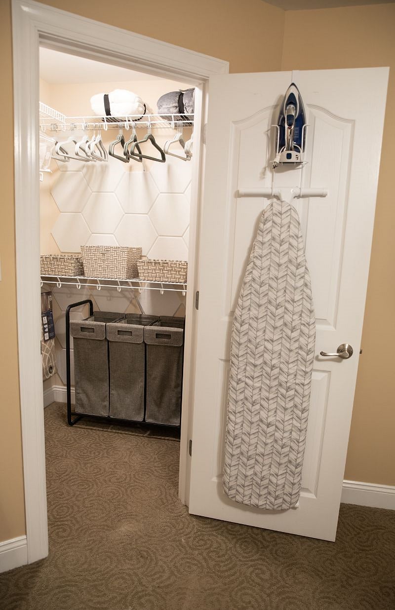 Master bedroom closet with extra rollaway bed for guests. Baskets for extra storage space.
