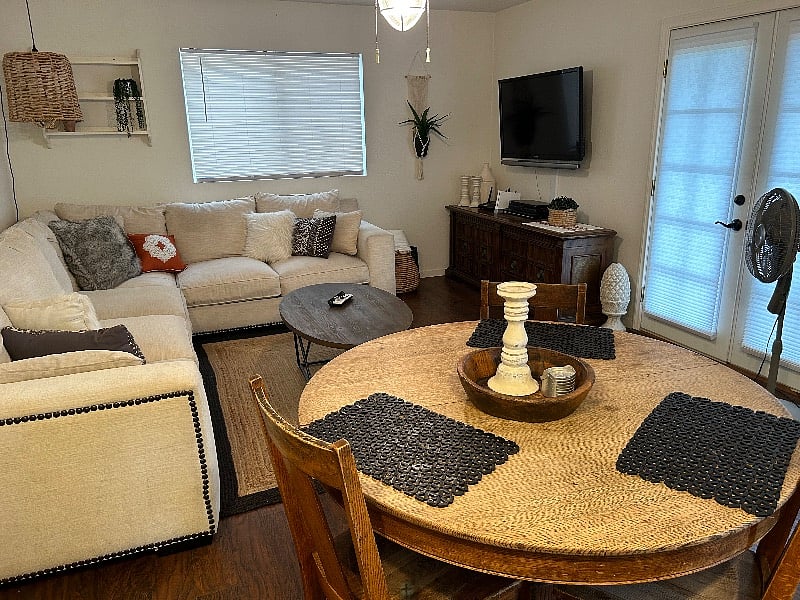Another angle of living room/dining room table area. French doors lead to grass and pool