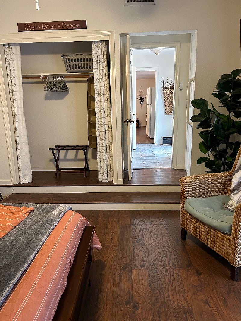 View from bedroom to front entrance and onto living room/kitchenette