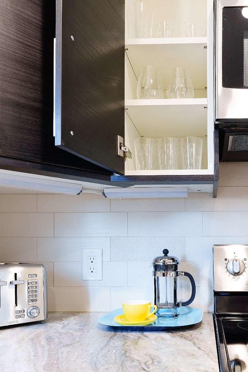 Kitchen is well stocked with glassware and wine glasses.